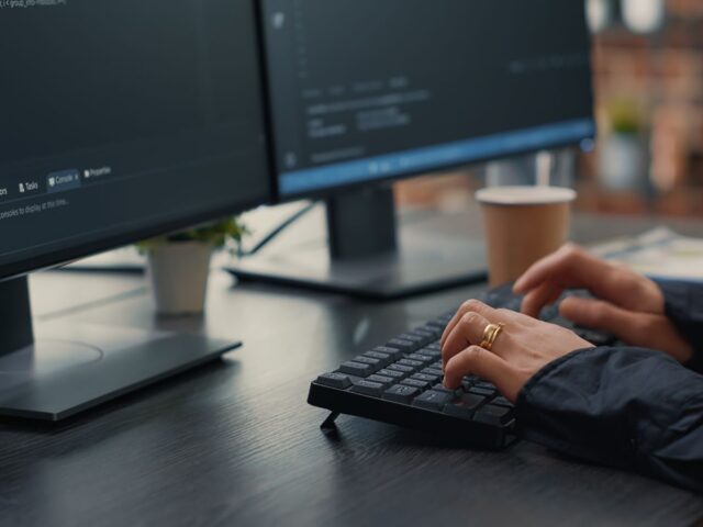 Programer sitting at desk with clipboard writing algorithm