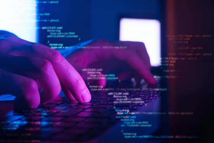 A man writes computer code in a program