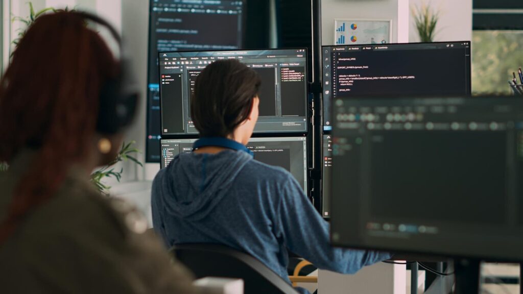 Programmers working on creating code, rear view