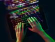 Human hands on keyboard with reflected program code